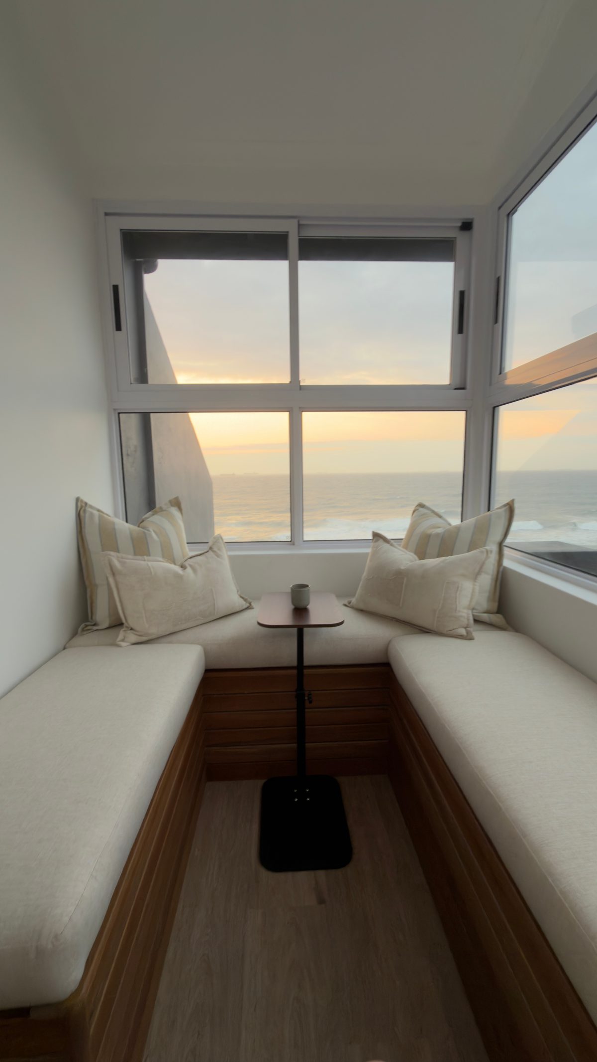 801 conversation pit with cushioned seats around a small table and sea views through the surrounding windows