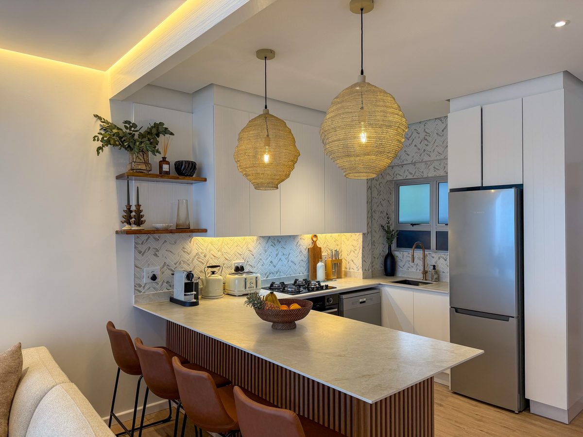 801's renovated kitchen with woven pendant lights, a breakfast counter and natural wood finishes