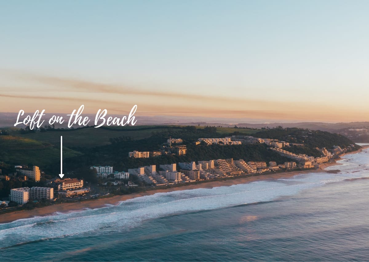 Umdloti's beachfront from the air at sunset, an arrow marking the loft's building